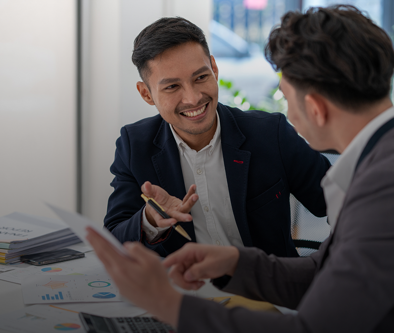 Two businessmen discussing at a desk.