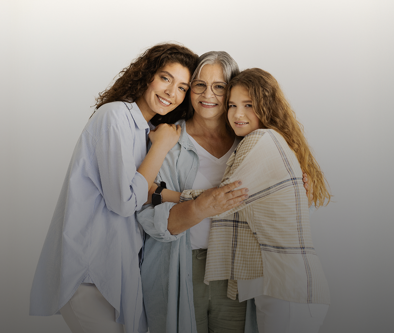 Three women smiling and embracing each other.