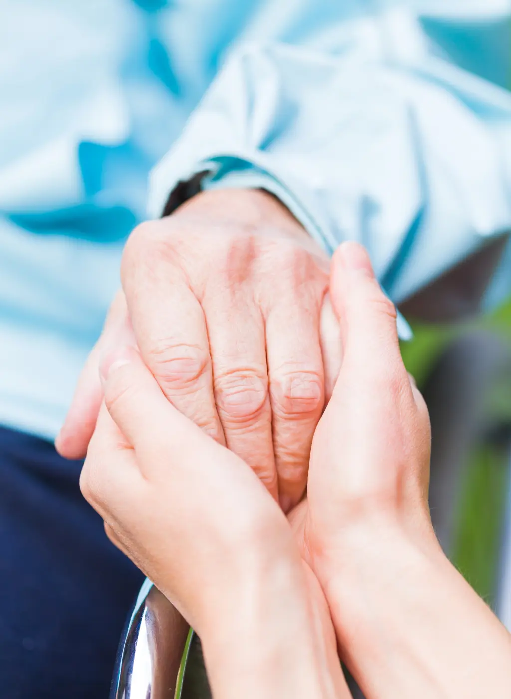 Hands holding in a comforting gesture.