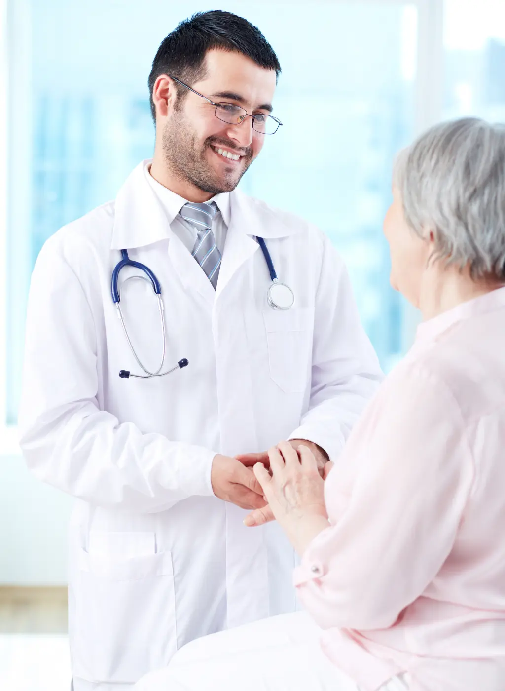 Doctor smiling while talking to elderly patient.